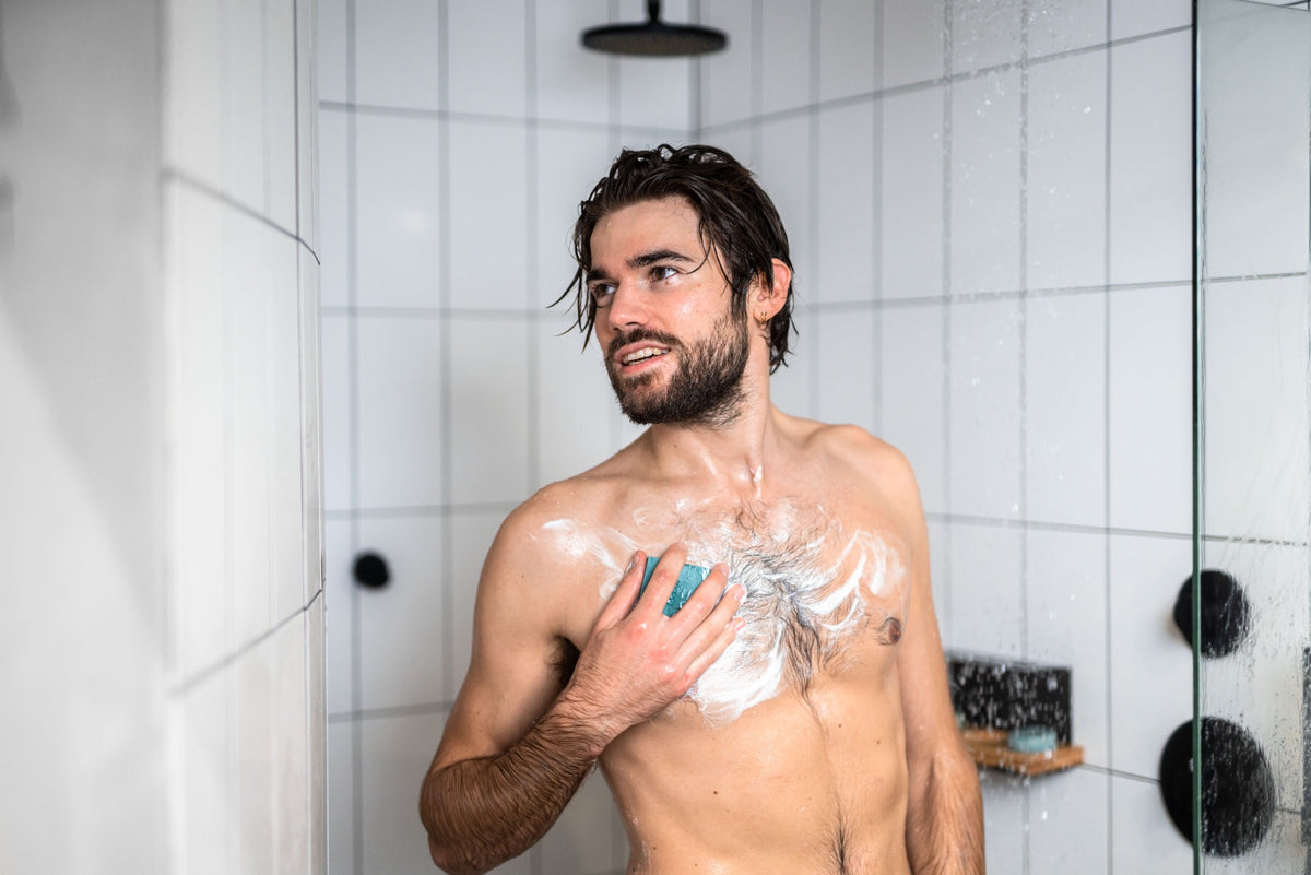 Man washing himself with plastic free body wash bar
