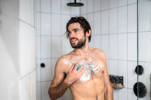 Man washing himself with plastic free body wash bar